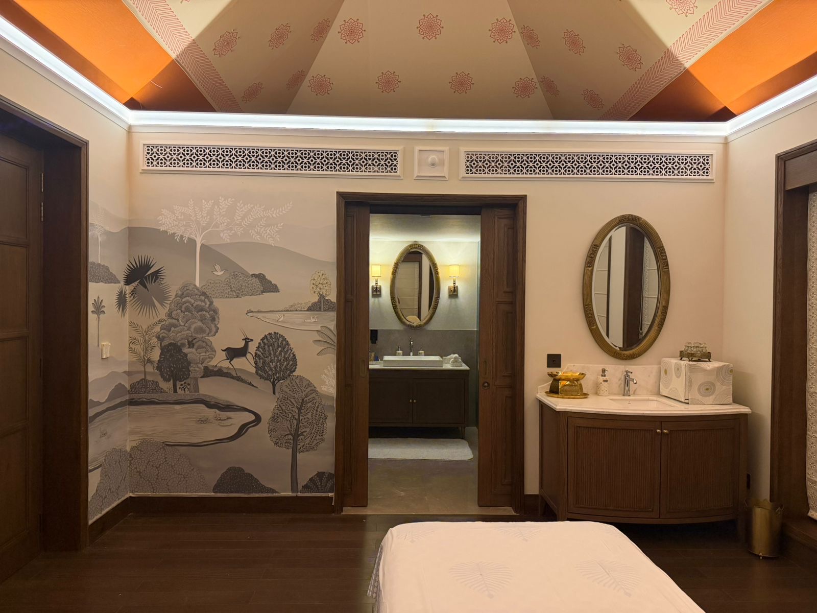 A spa room with a grey-blue forest mural and patterned ceiling — Artemist Consultancy, hospitality
